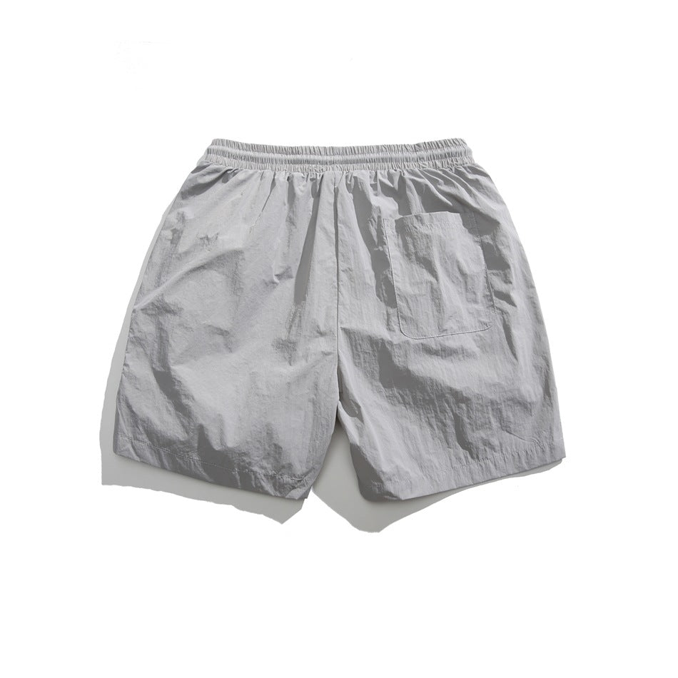 Back view of light gray shorts with an elastic waistband and a single rear patch pocket.