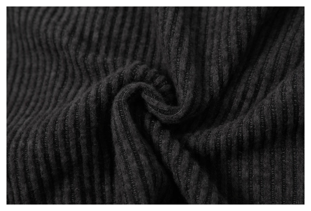 Close-up of black ribbed fabric gathered into a swirl, showing its raised texture.