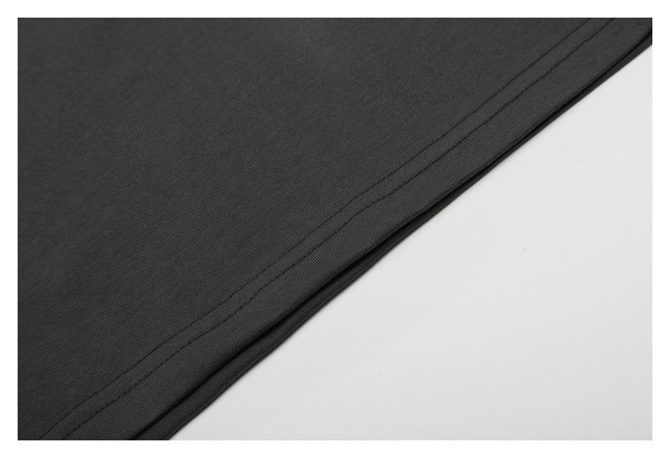 Close-up of dark charcoal fabric with a neatly stitched folded hem.