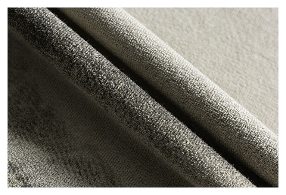 Close-up of folded knit fabric showing its textured surface in light gray and charcoal tones.