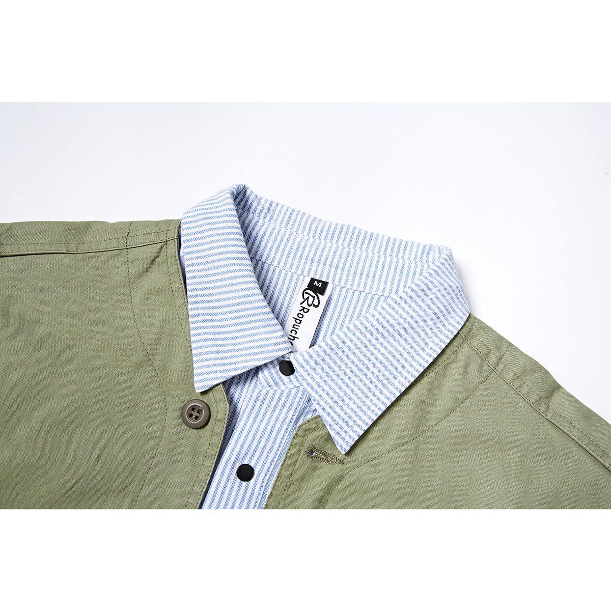 Close-up of an olive jacket’s blue-and-white striped collar and placket, with buttons and a small neck label.