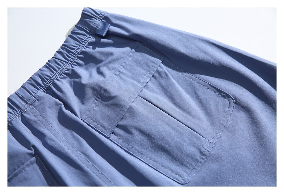 Close-up of a large flap pocket and elastic waistband on blue cargo trousers.