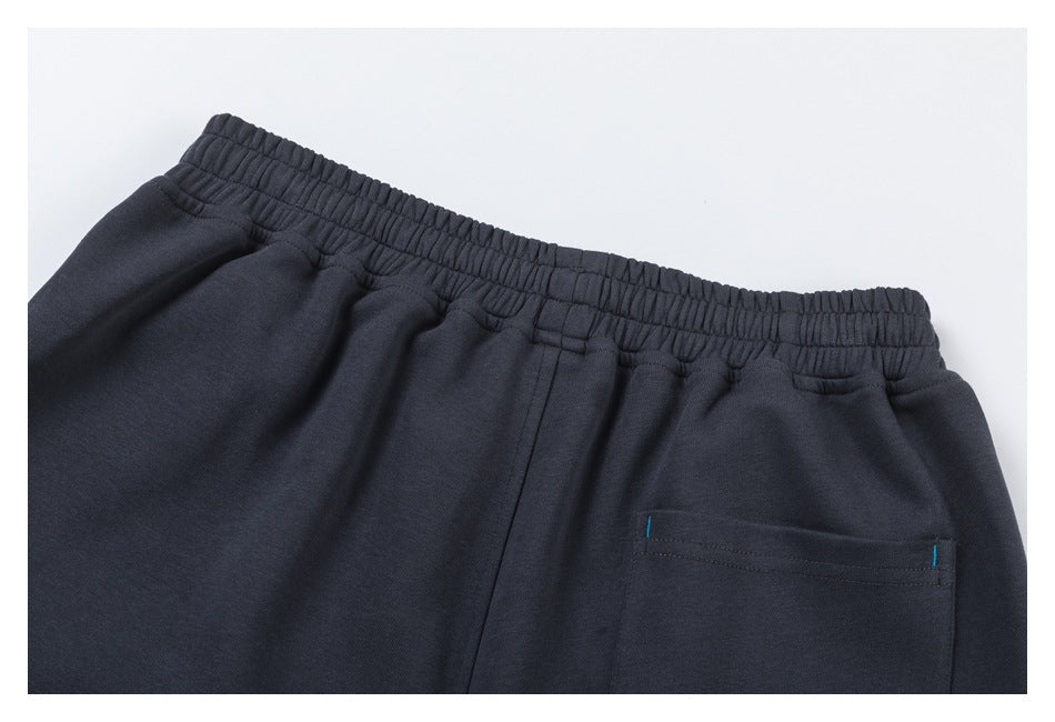 Close-up of the elastic waistband and back pocket on charcoal jogger pants.