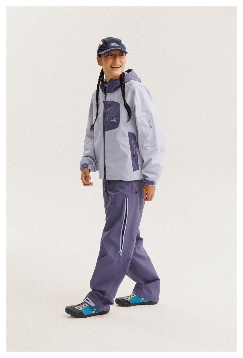 Model in a light lavender jacket with purple trim and matching pants, shown in a side-facing pose.