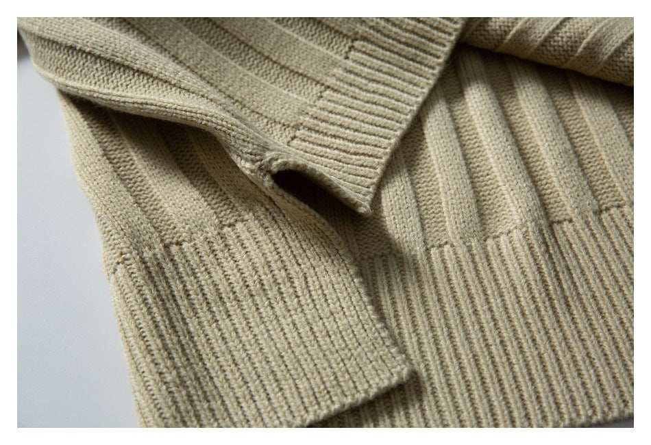 Close-up of a beige ribbed knit sweater section with overlapping fabric and a ribbed edge.