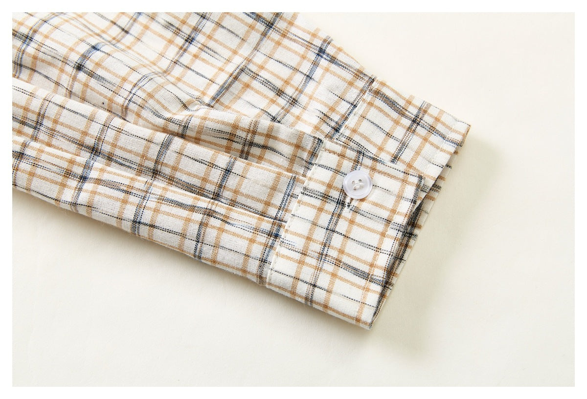 Close-up of a cream plaid shirt sleeve and buttoned cuff.