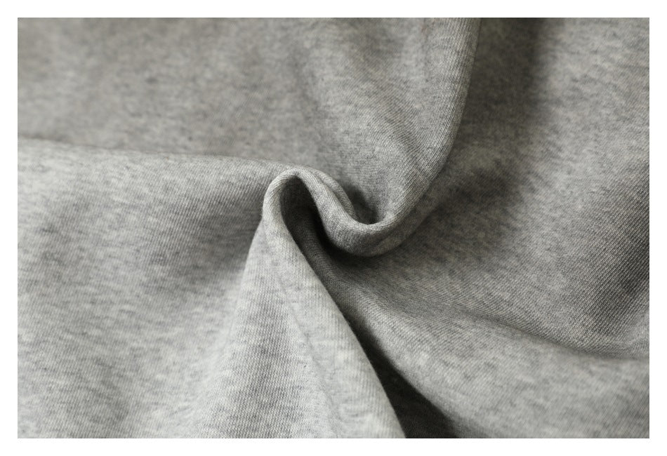 Close-up of heather gray fabric gathered into soft folds, showing its fine knit texture.