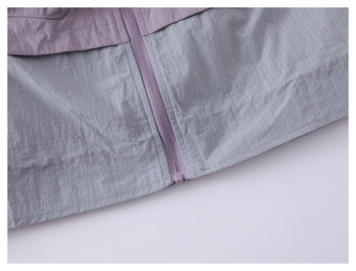 Close-up of the jacket's lavender zipper and gray grid-patterned lower hem.