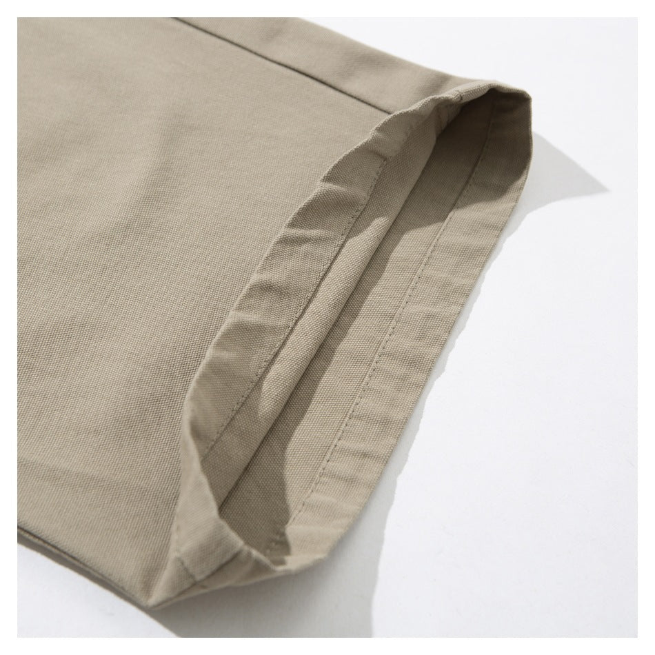 Close-up of the stitched, folded hem on beige trousers.