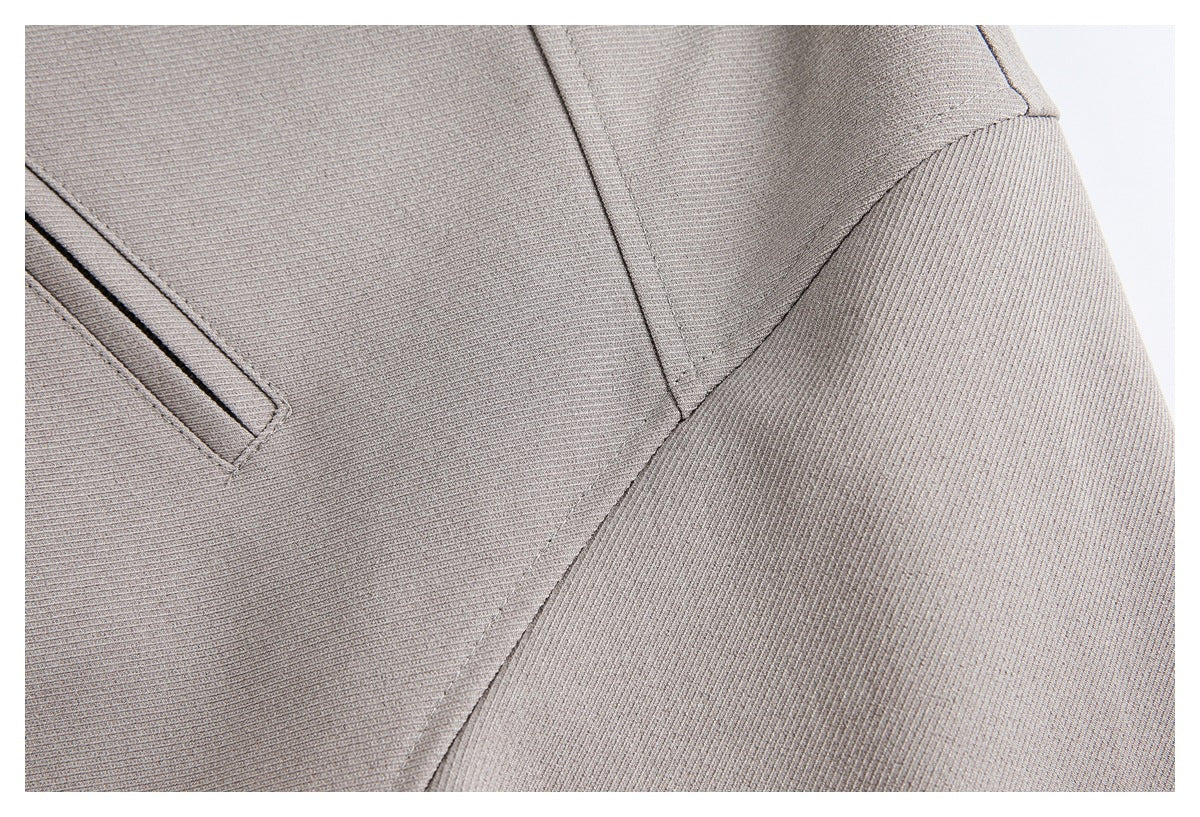 Close-up of taupe jacket fabric, stitched seams, and a ribbed panel.