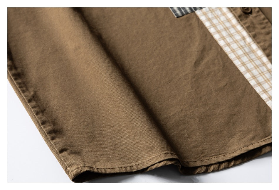 Close-up of a brown shirt hem with stitching and a glimpse of beige plaid trim.