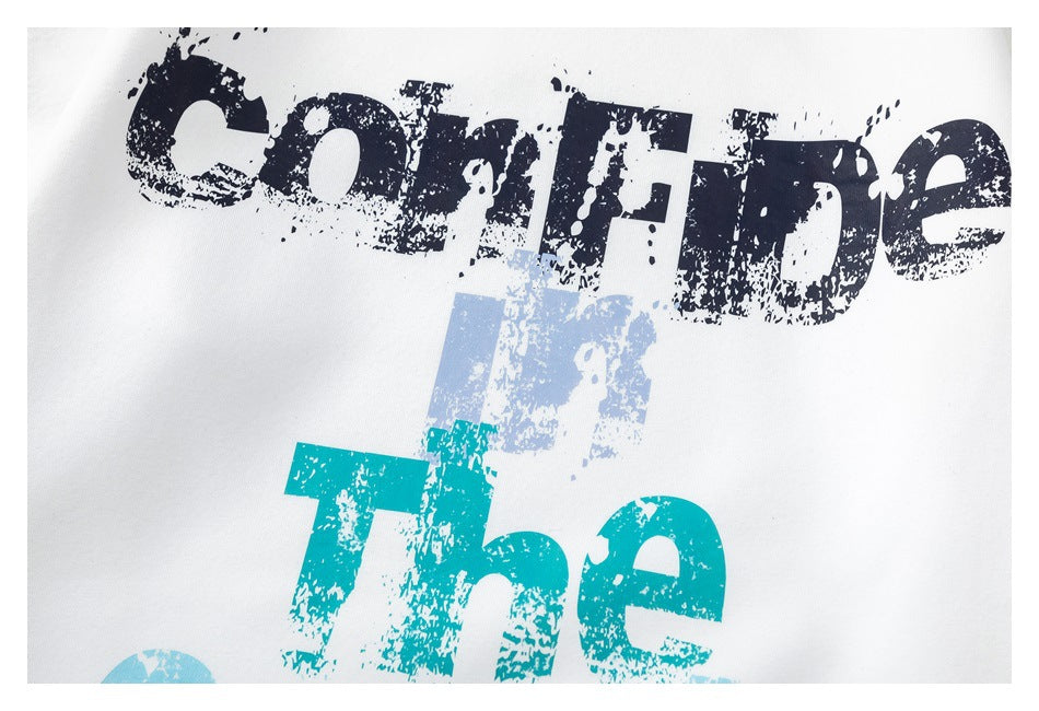 Tight crop of distressed navy and teal English lettering printed on white sweatshirt fabric.