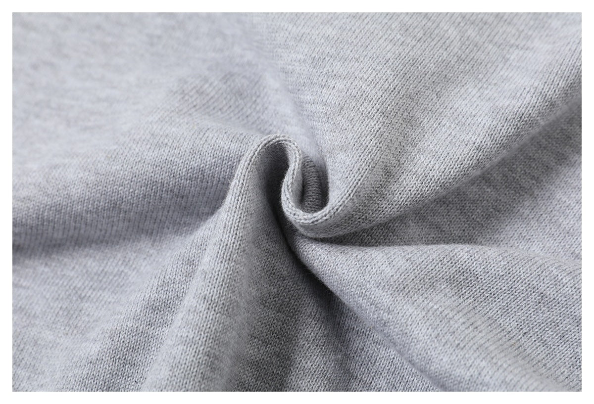 Close-up of the light gray knit fabric twisted into a fold to show its drape and texture.