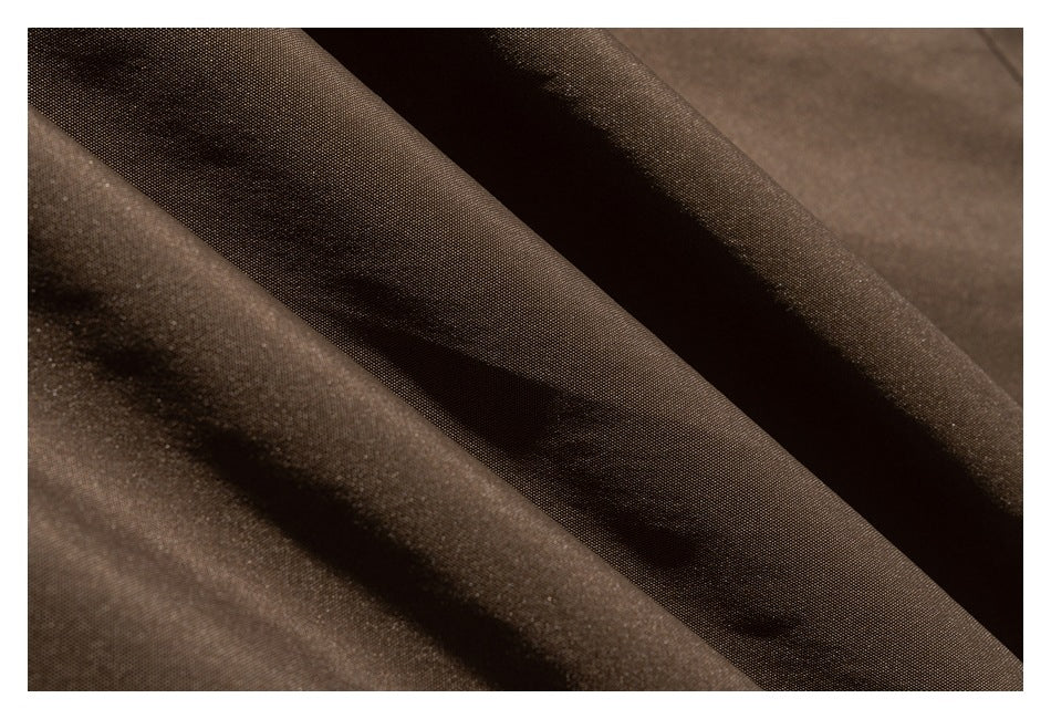 Close-up of dark brown fabric shown in soft folds.