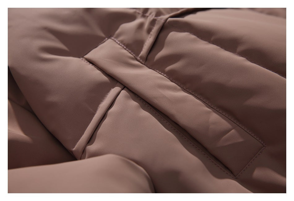 Close-up of taupe-brown jacket fabric and overlapping stitched pocket or flap details.
