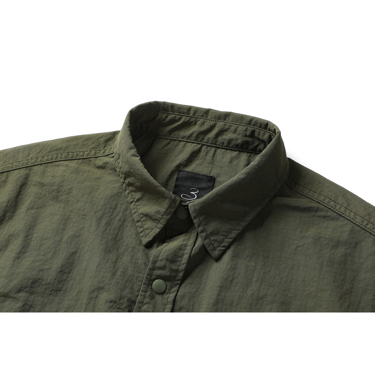 Close-up of an olive-green shirt collar with a dark label and snap-button placket.