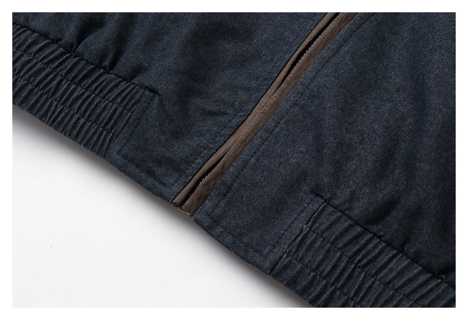 Close-up of a dark jacket hem with brown zipper trim and gathered ribbed panels.