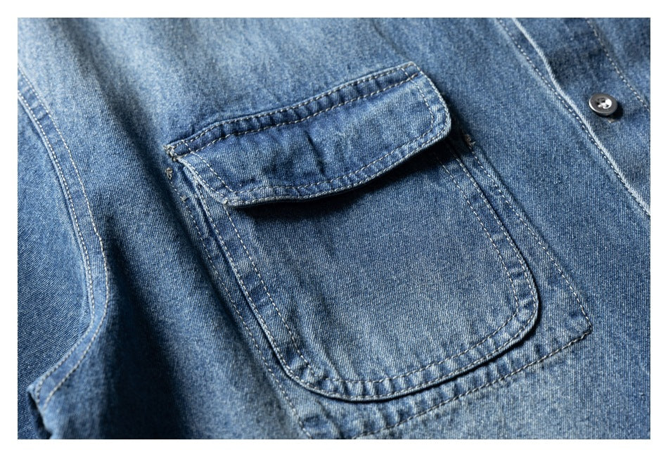 Close-up of a blue denim shirt's flap chest pocket and button placket.