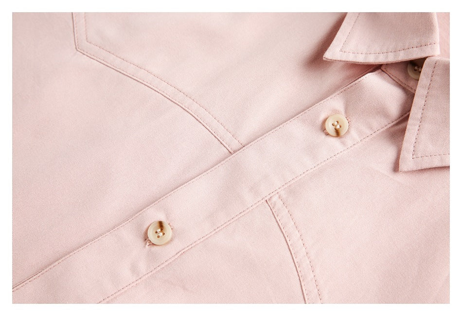 Close-up of the pale pink shirt's button placket, buttons, and stitched seams.