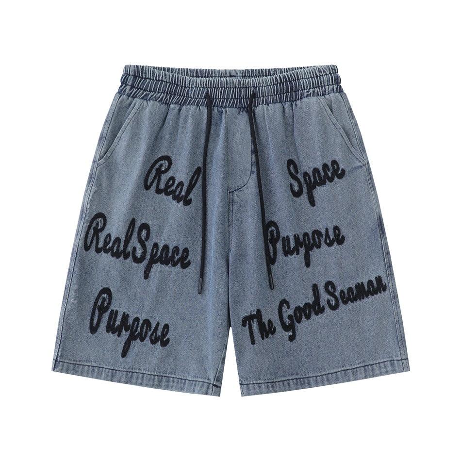 Washed blue denim shorts with elastic drawstring waist and black script lettering across the front