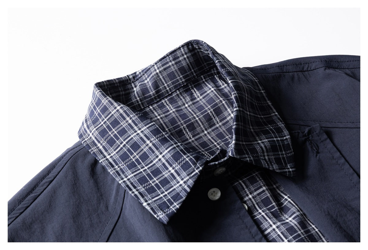 Close-up of a navy shirt's white-and-gray plaid collar and matching inner placket.