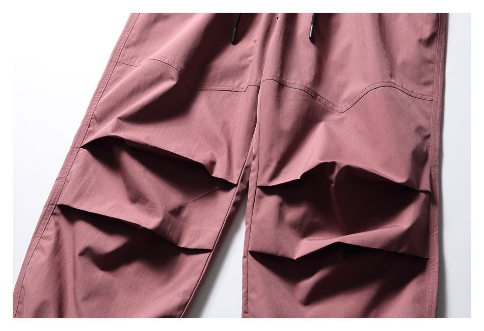 Close-up of the dusty rose pants' sculpted knee pleats and curved seam detailing.