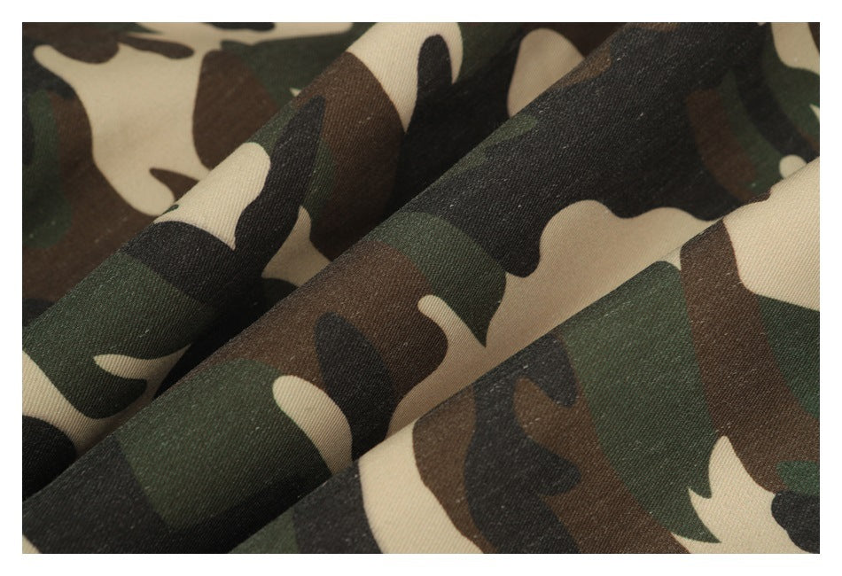 Close-up of folded fabric showing a green, brown, black, and tan camouflage print.