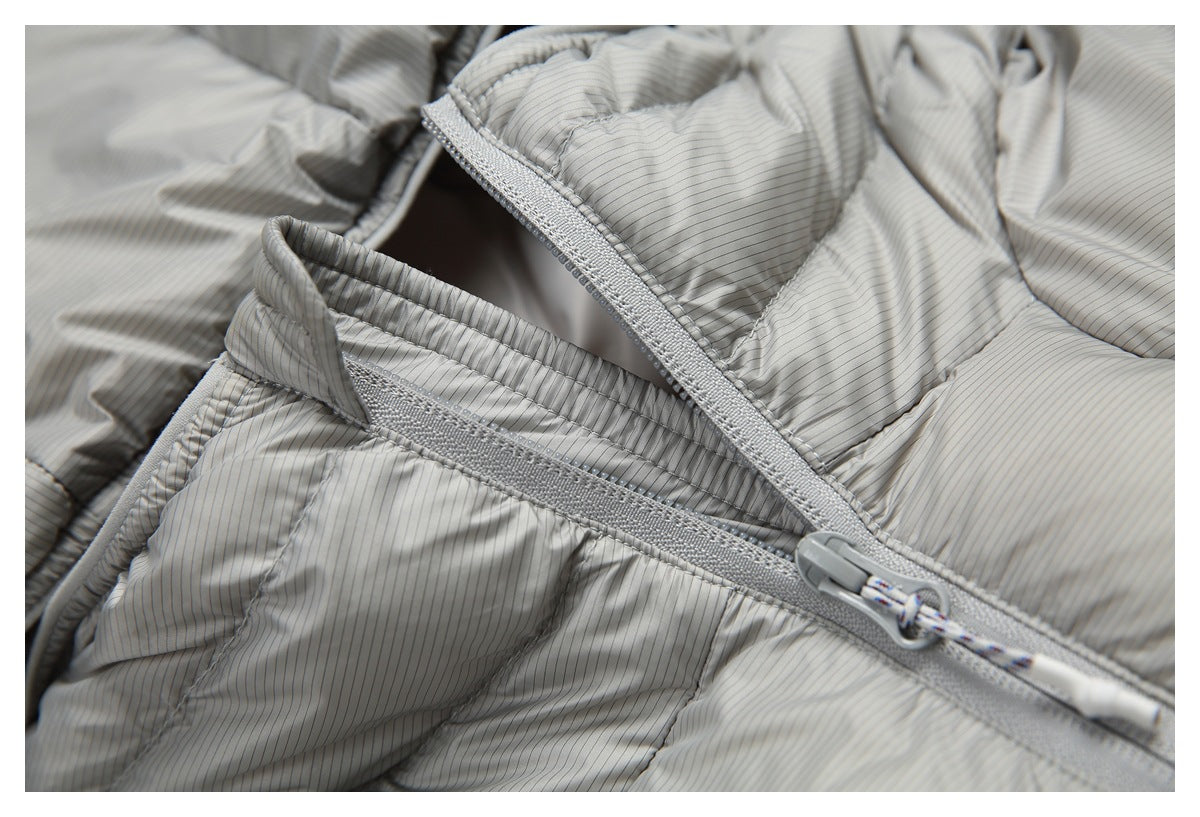Close-up of a light gray pinstriped puffer jacket with a gray front zipper and corded pull.
