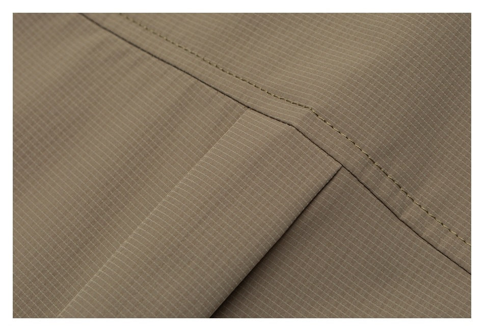 Close-up of overlapping taupe garment panels with a curved stitched seam.