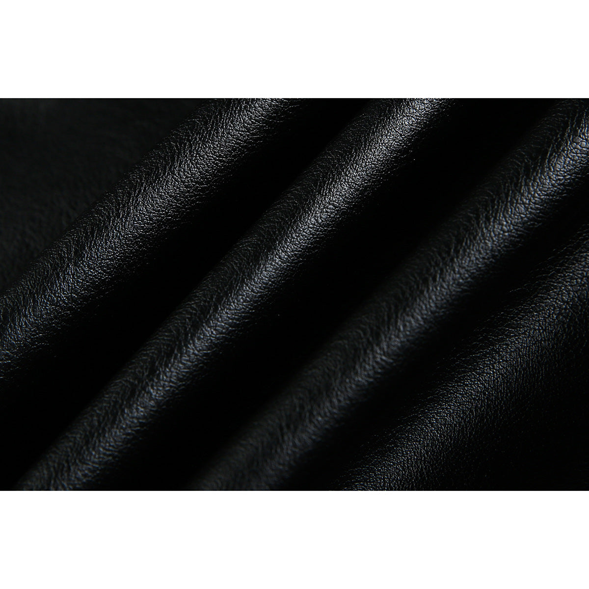 Extreme close-up of the black jacket's pebbled, glossy surface and folds.