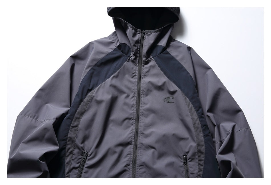 Front view of a charcoal-gray hooded jacket with a black center zipper, dark contrast panels and a small chest emblem.