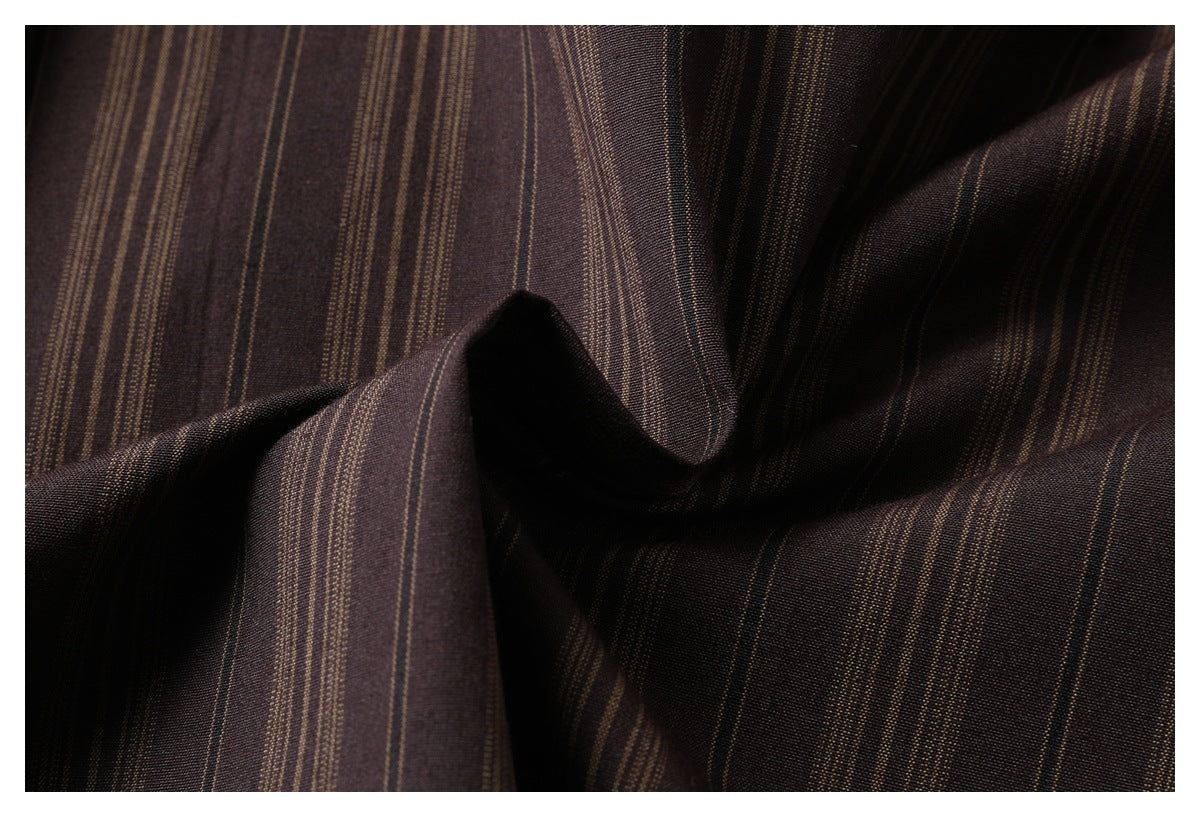Close-up of dark brown fabric with narrow tan stripes arranged in folds.