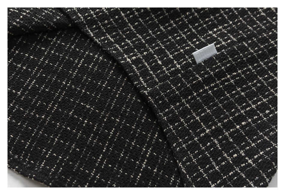 Close-up of folded black-and-cream patterned fabric with a small white label.