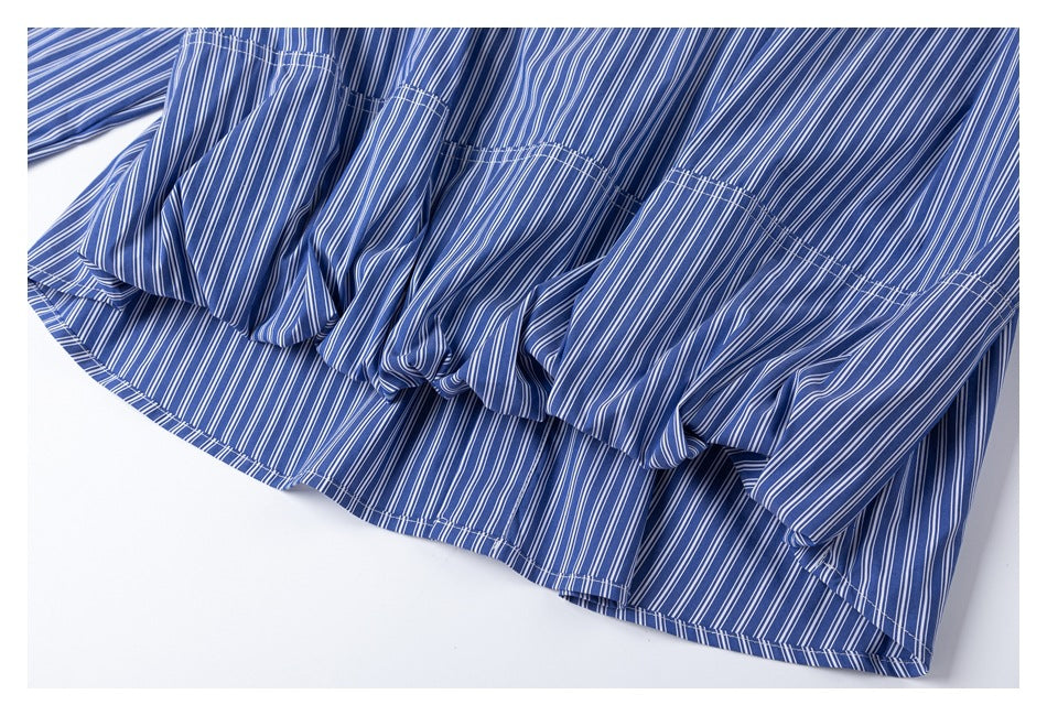 Close-up of a blue-and-white vertically striped garment with a gathered, ruffled hem.