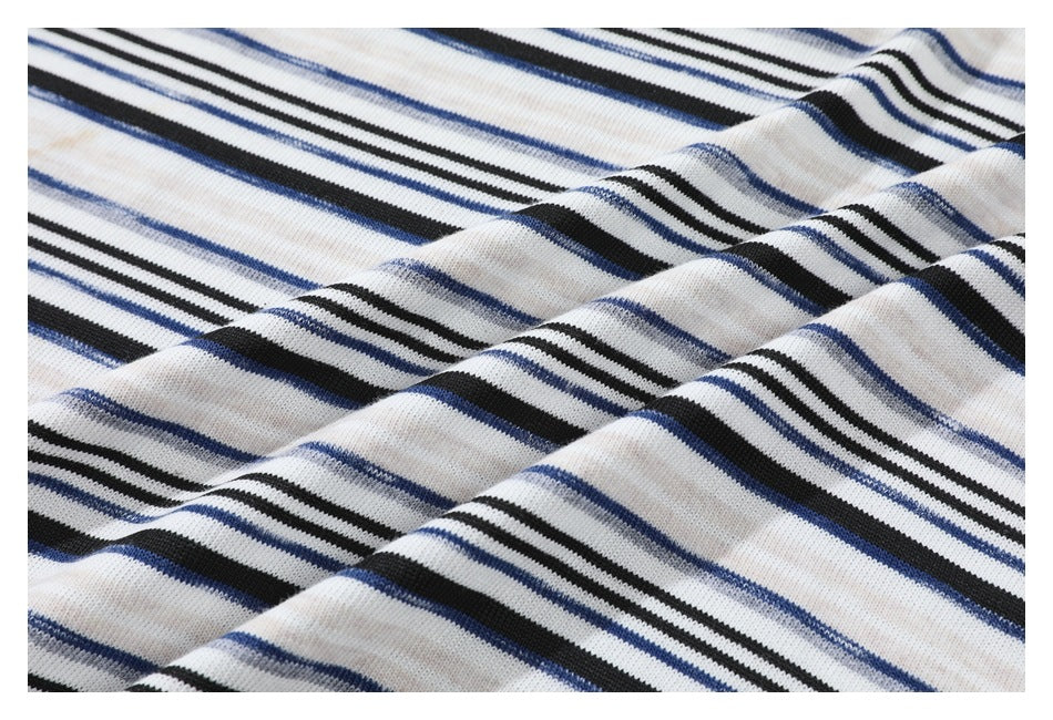 Close-up of cream shirt fabric with narrow black and blue horizontal stripes, shown in soft folds.