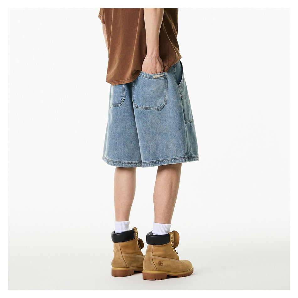 Rear three-quarter view of a person wearing light-wash denim shorts with back pockets and tan boots.