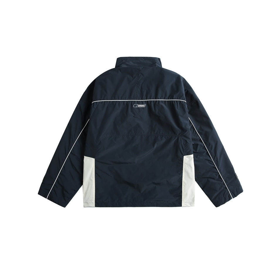 Back view of a navy jacket with white lower side panels and white piping, shown flat on white.