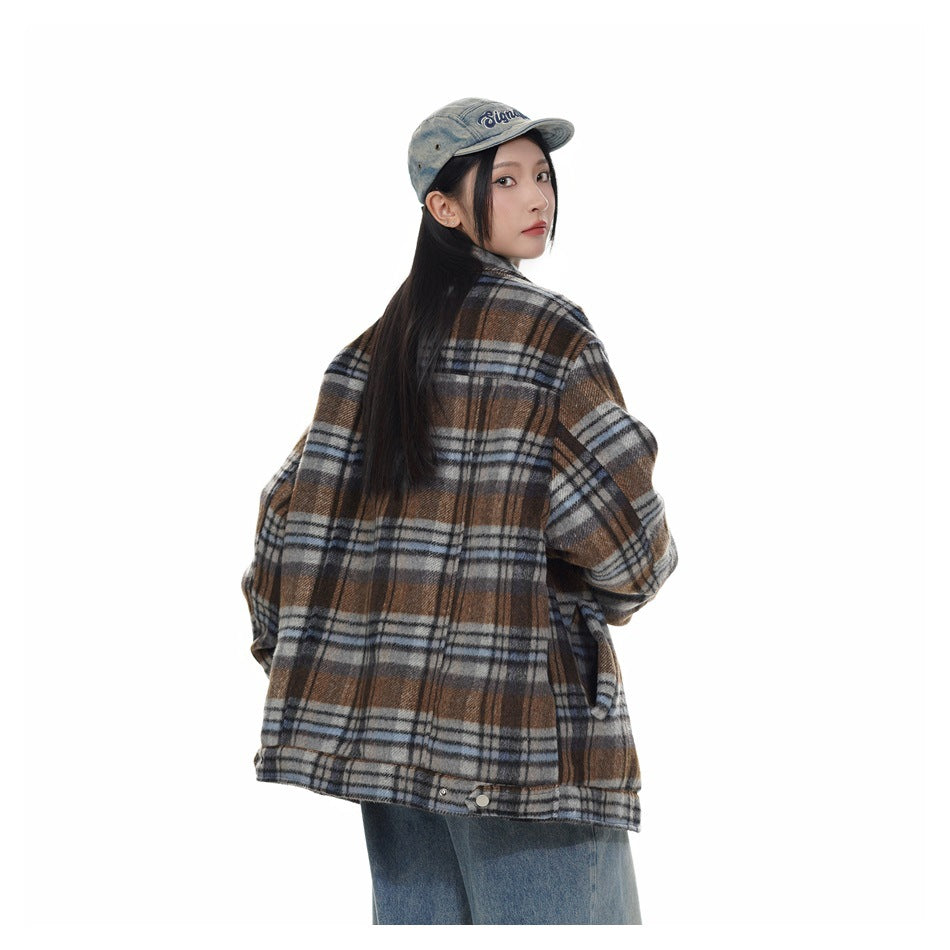 Model looking back over her shoulder, showing the back of a brown, gray, and blue plaid jacket.