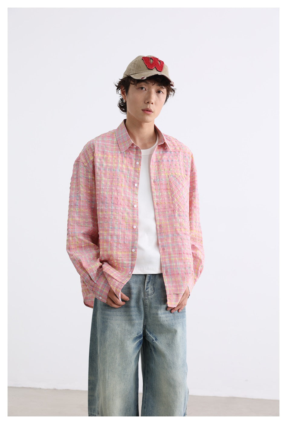 Front view of a model in a pink multicolor plaid shirt with white buttons and a chest pocket.