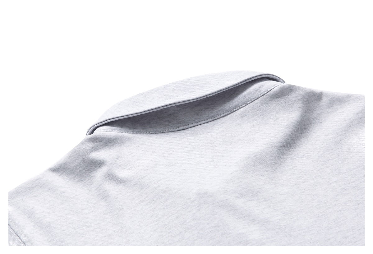 Close-up of the folded collar and shoulder area of a light gray knit garment.