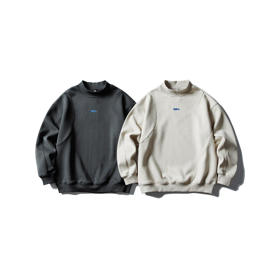 Two front-view mock-neck sweatshirts, one charcoal and one off-white, each with a small blue chest emblem.