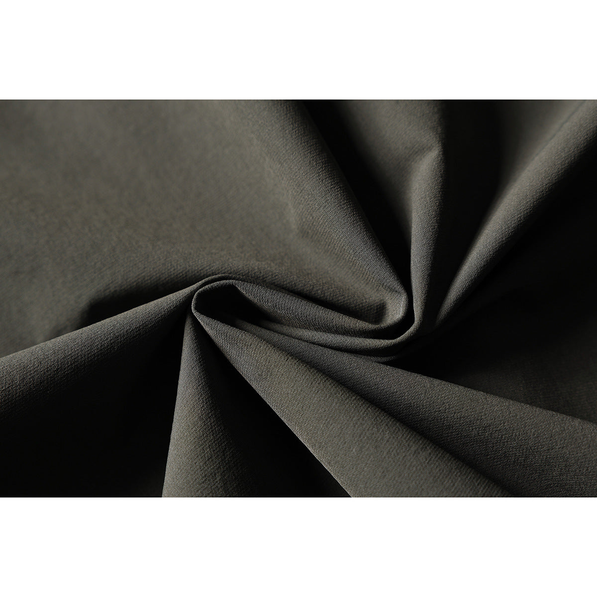 Close-up of dark olive-gray fabric gathered into folds, showing its surface texture.