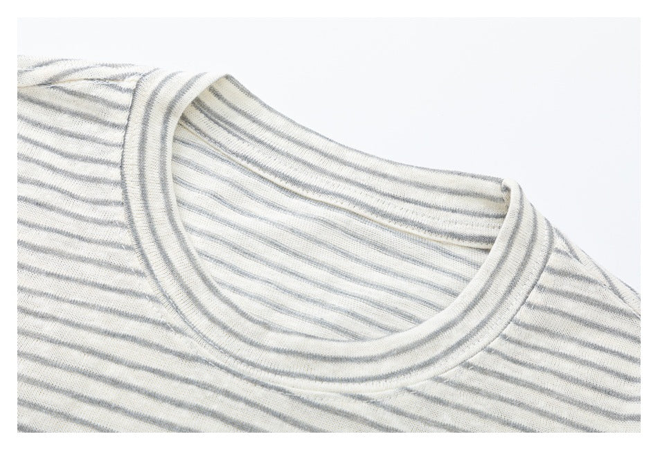 Close-up of the rounded neckline and narrow gray stripes on an off-white knit top.