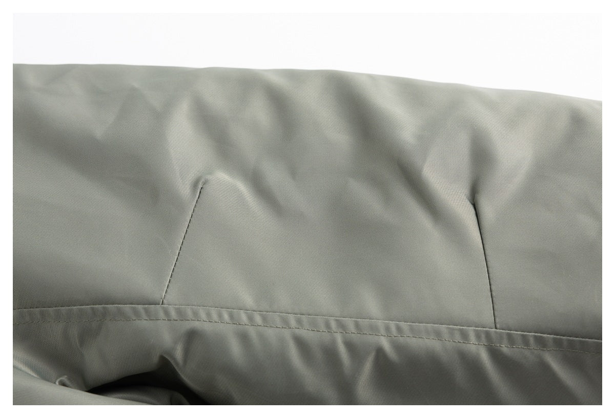 Close-up of stitched panels and a horizontal seam on the olive-gray jacket.