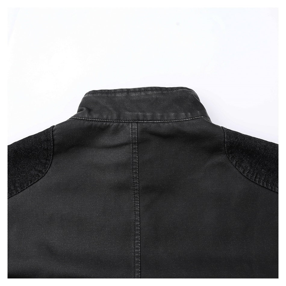 Close-up of the back of a black jacket, showing its raised collar, center seam and contrasting shoulder panels.