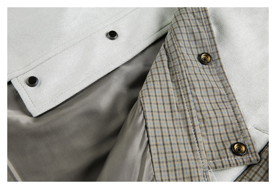 Close-up of a light gray jacket opening with beige-and-blue plaid lining and dark snap buttons.