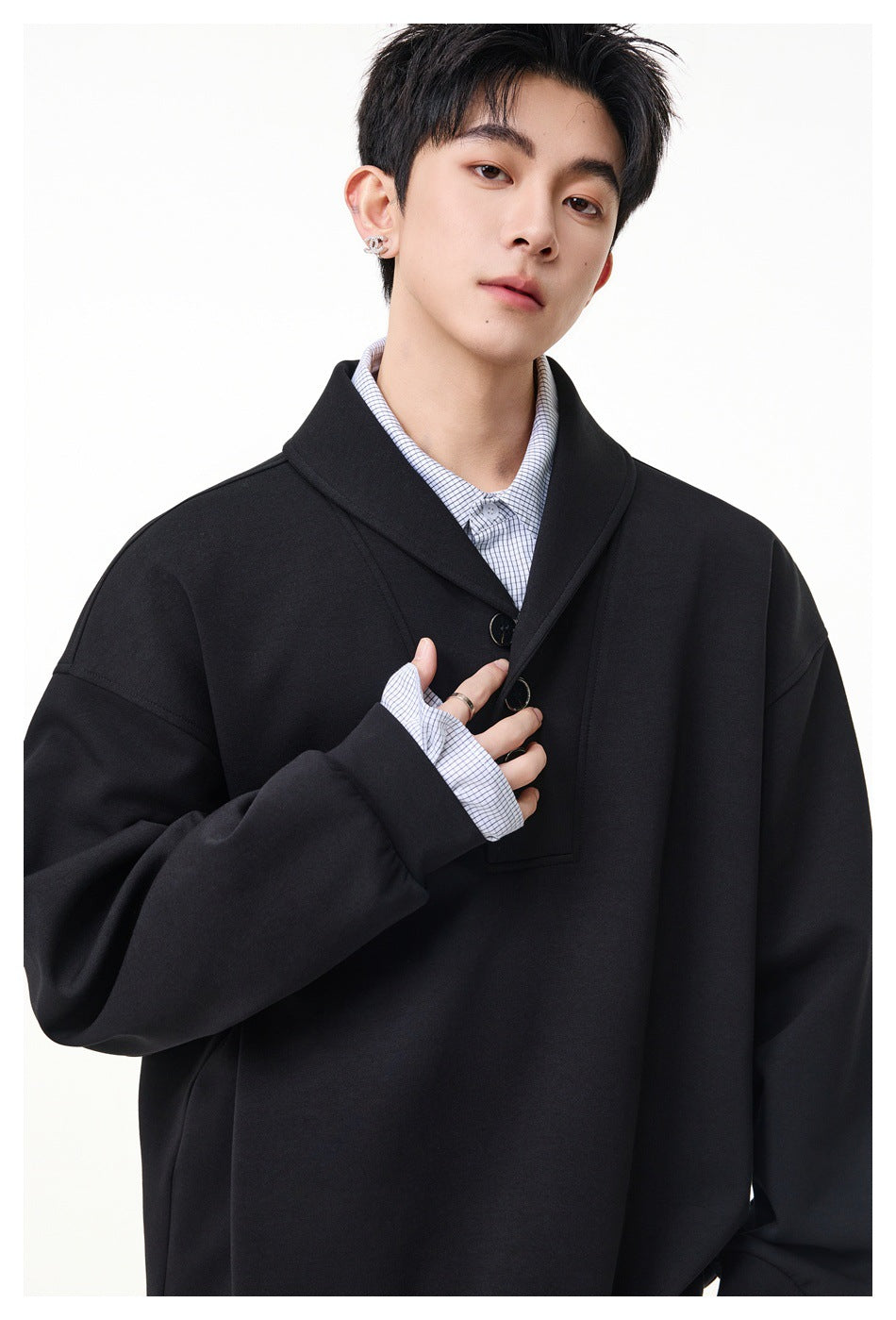 Close-up of a black pullover's wide collar and three-button placket on a model.