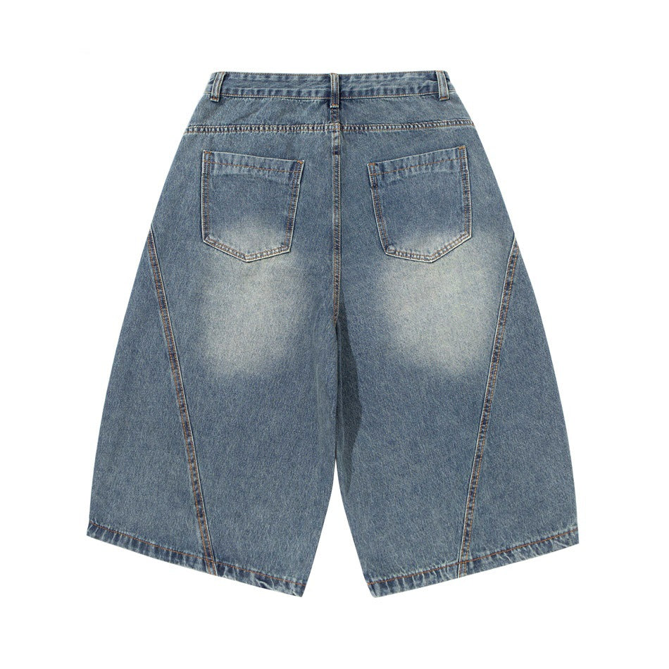 Back view of washed blue denim shorts with two patch pockets, faded seat and curved leg seams