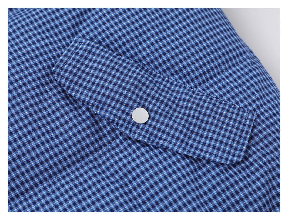 Close-up of a blue checked jacket cuff with a single snap button.
