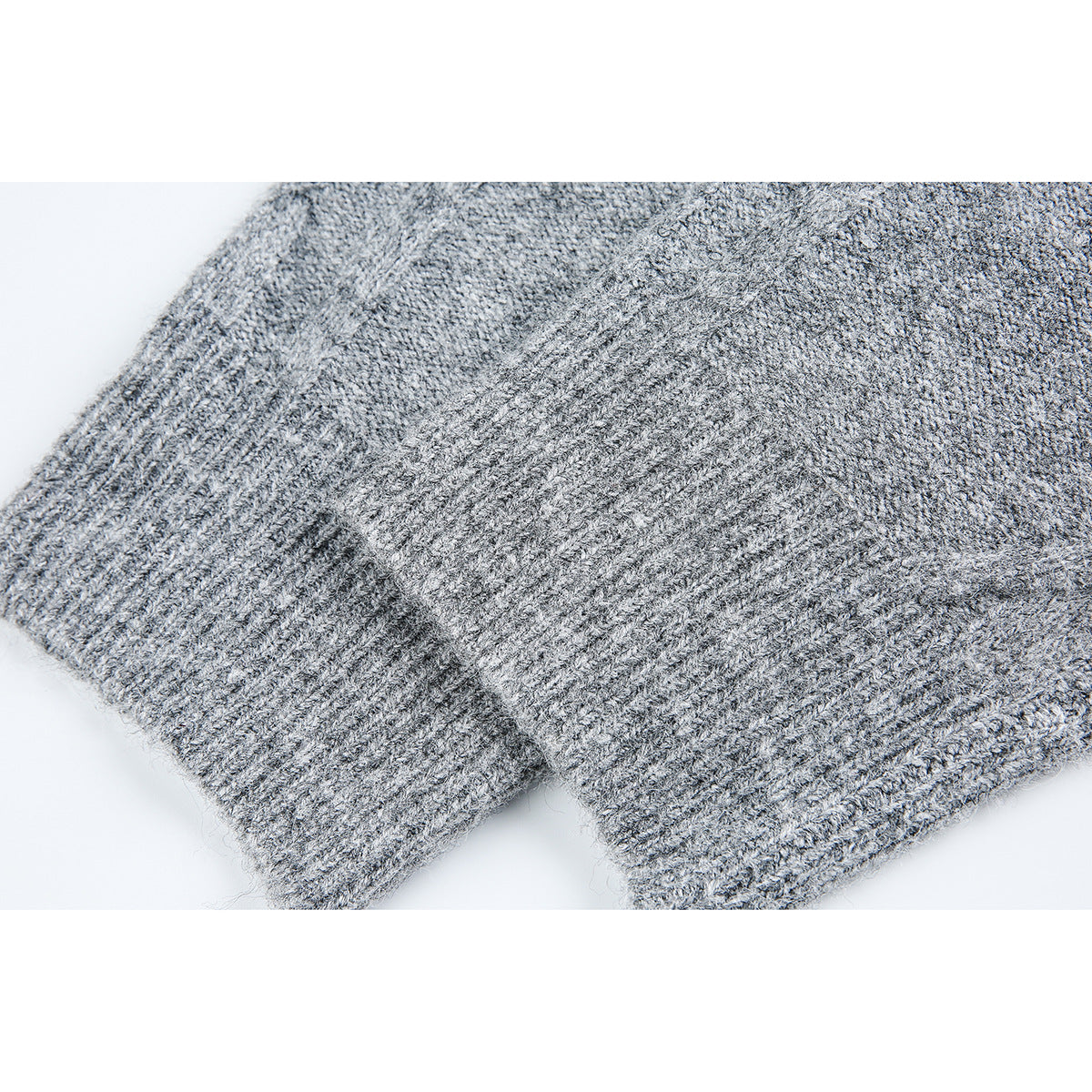 Close-up of a gray knit sweater sleeve and ribbed cuff.